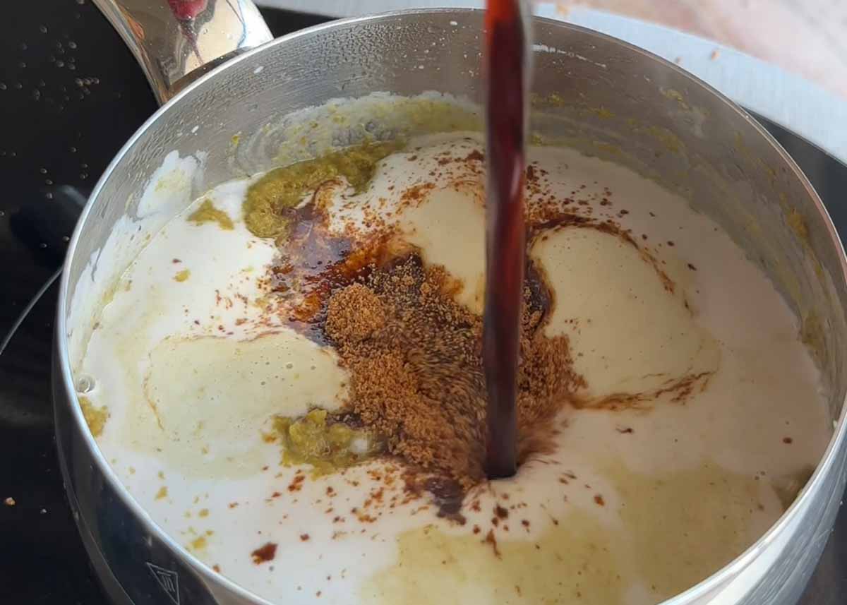 Green Thai curry paste cooking in coconut milk to make a creamy curry sauce.