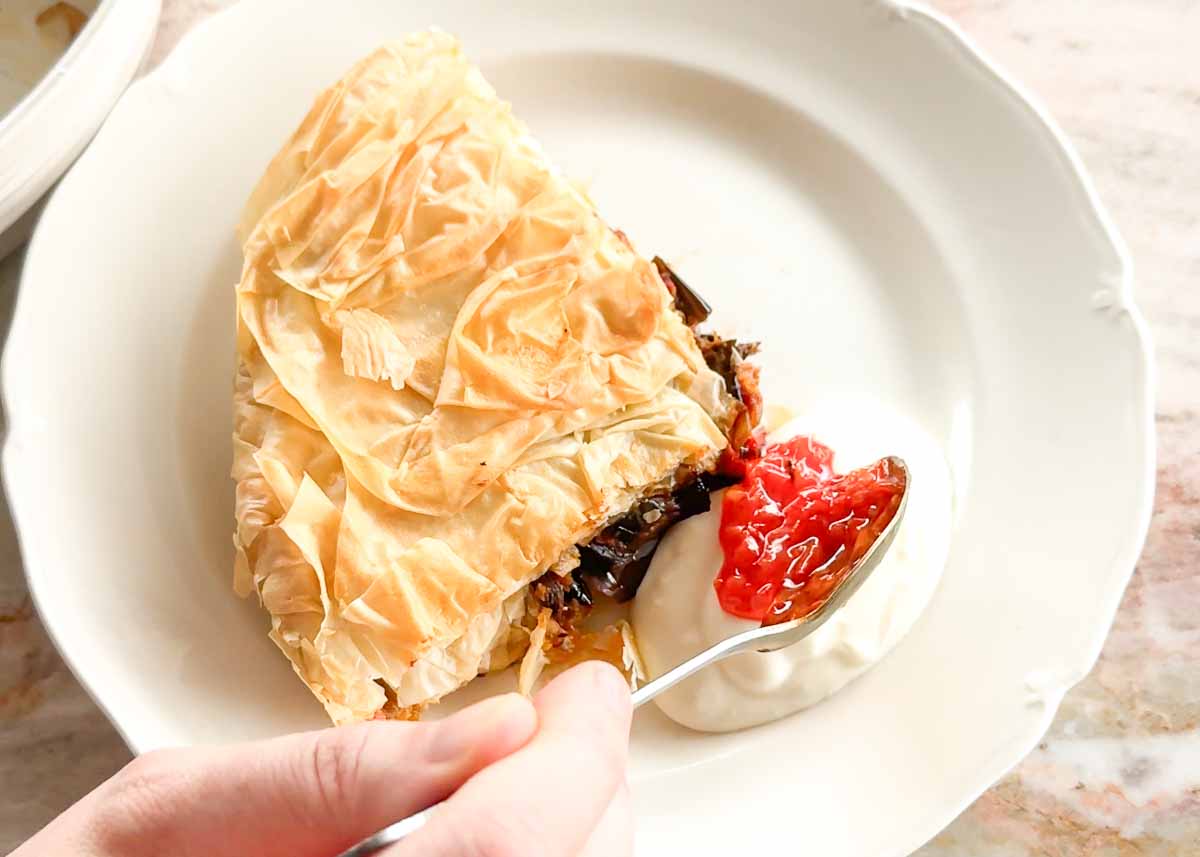 Slice of crispy eggplant börek served with roasted capsicum relish.