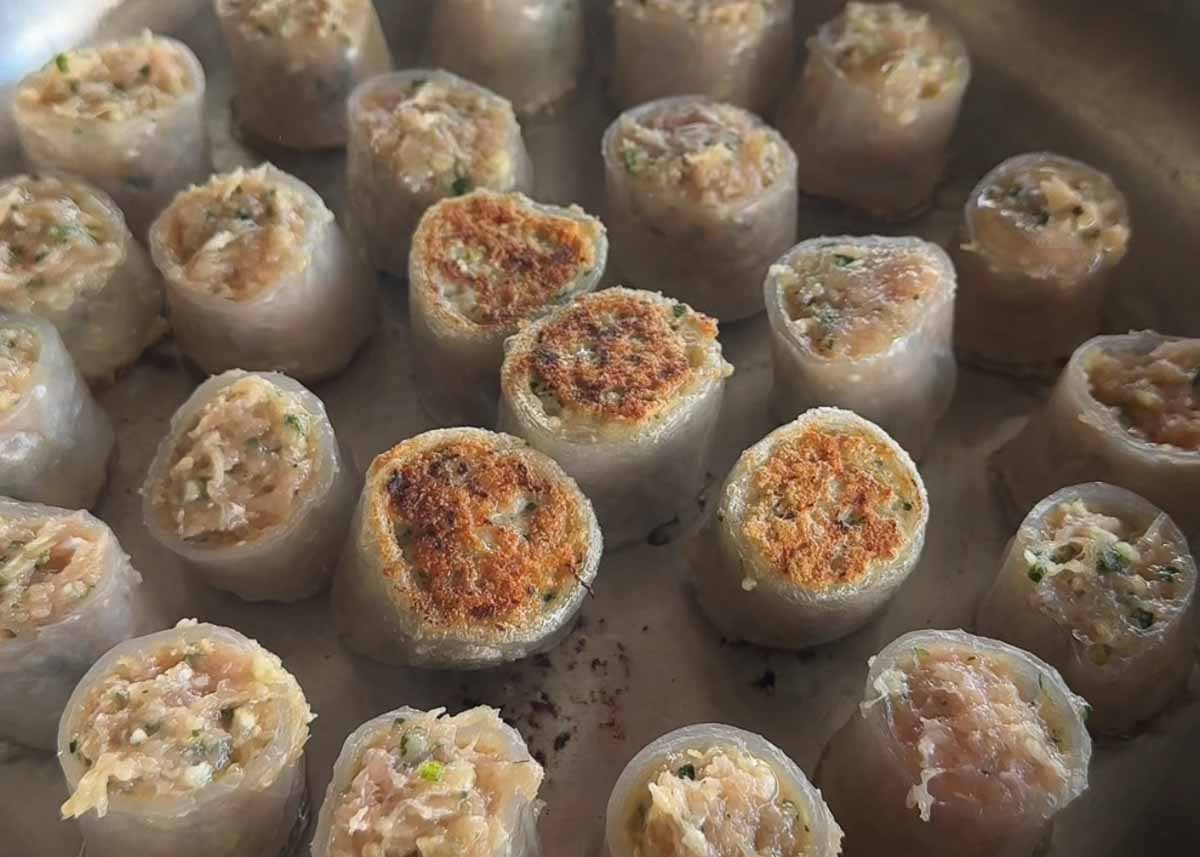 Chicken rice paper dumplings cooking until golden and crispy in a frying pan.