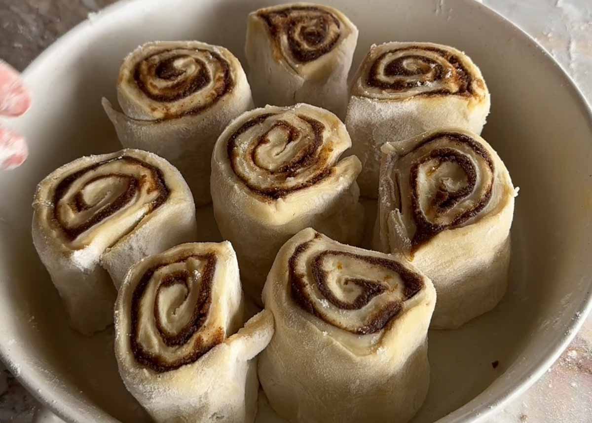 Brown butter cardamom sourdough scrolls shaped and arranged in a baking dish before proofing.