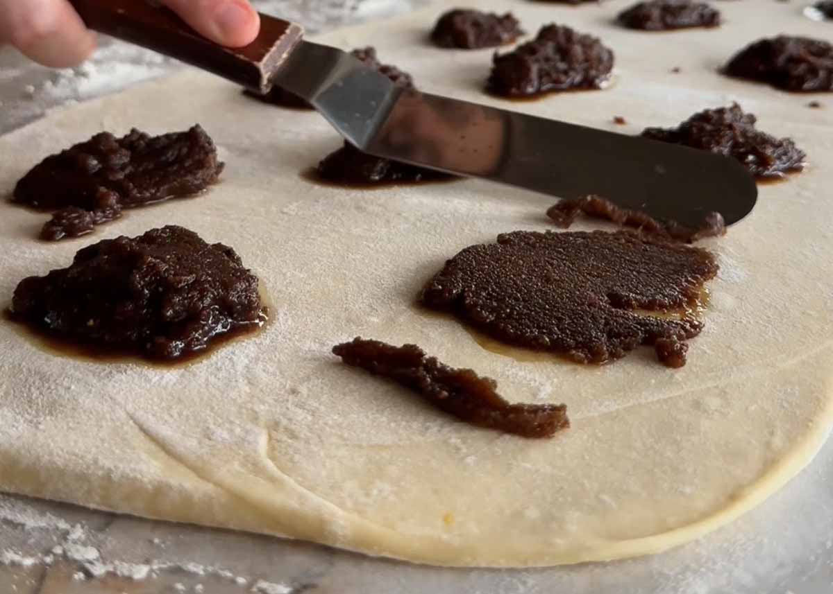 Brown butter cardamom filling being spread over rolled sourdough dough.