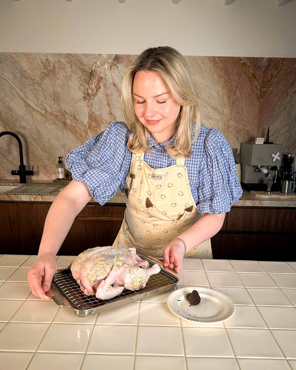sezzy brown placing truffle roast chicken into the oven