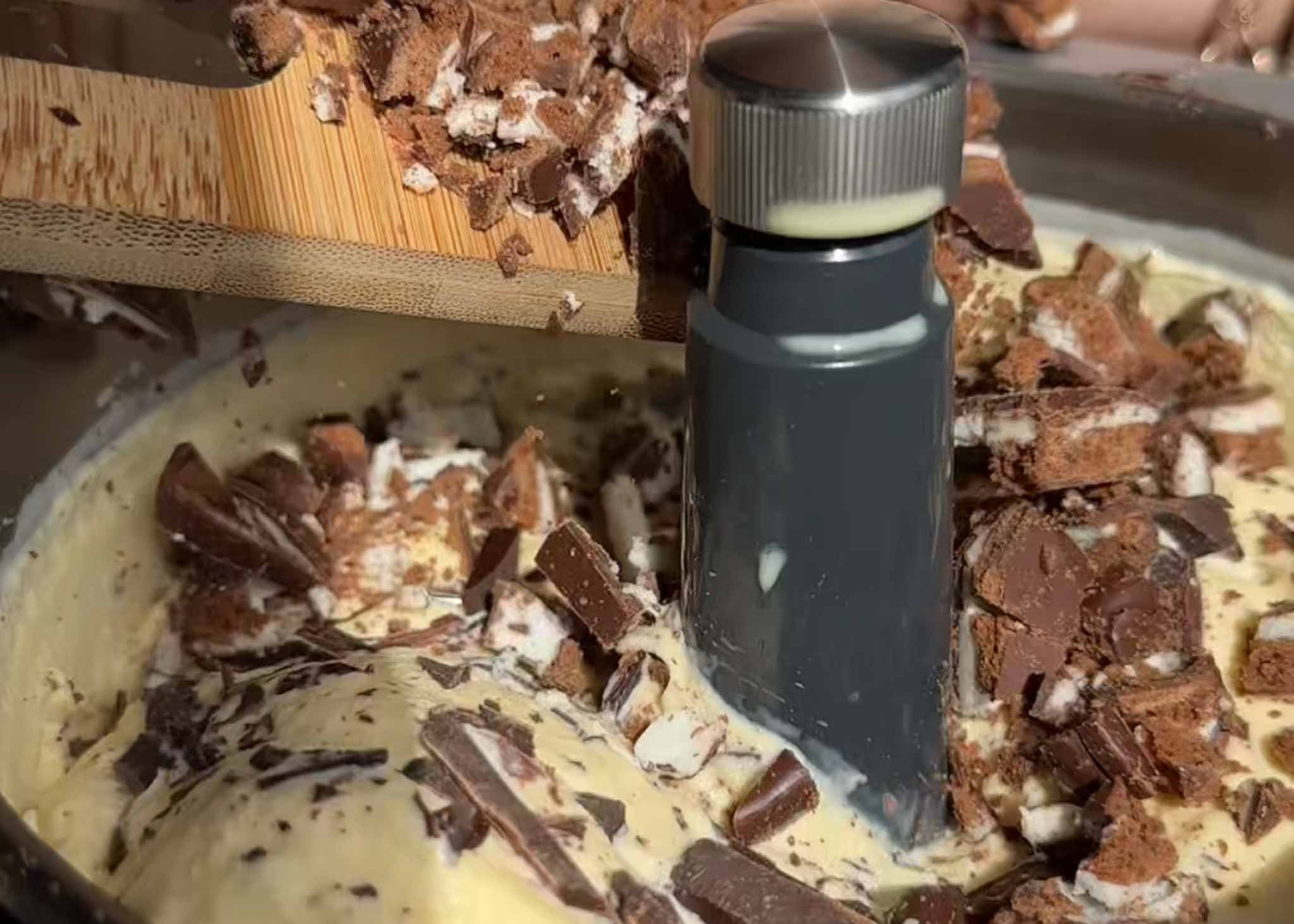 Chopped Mint Slice biscuits and dark chocolate being added to churned ice cream