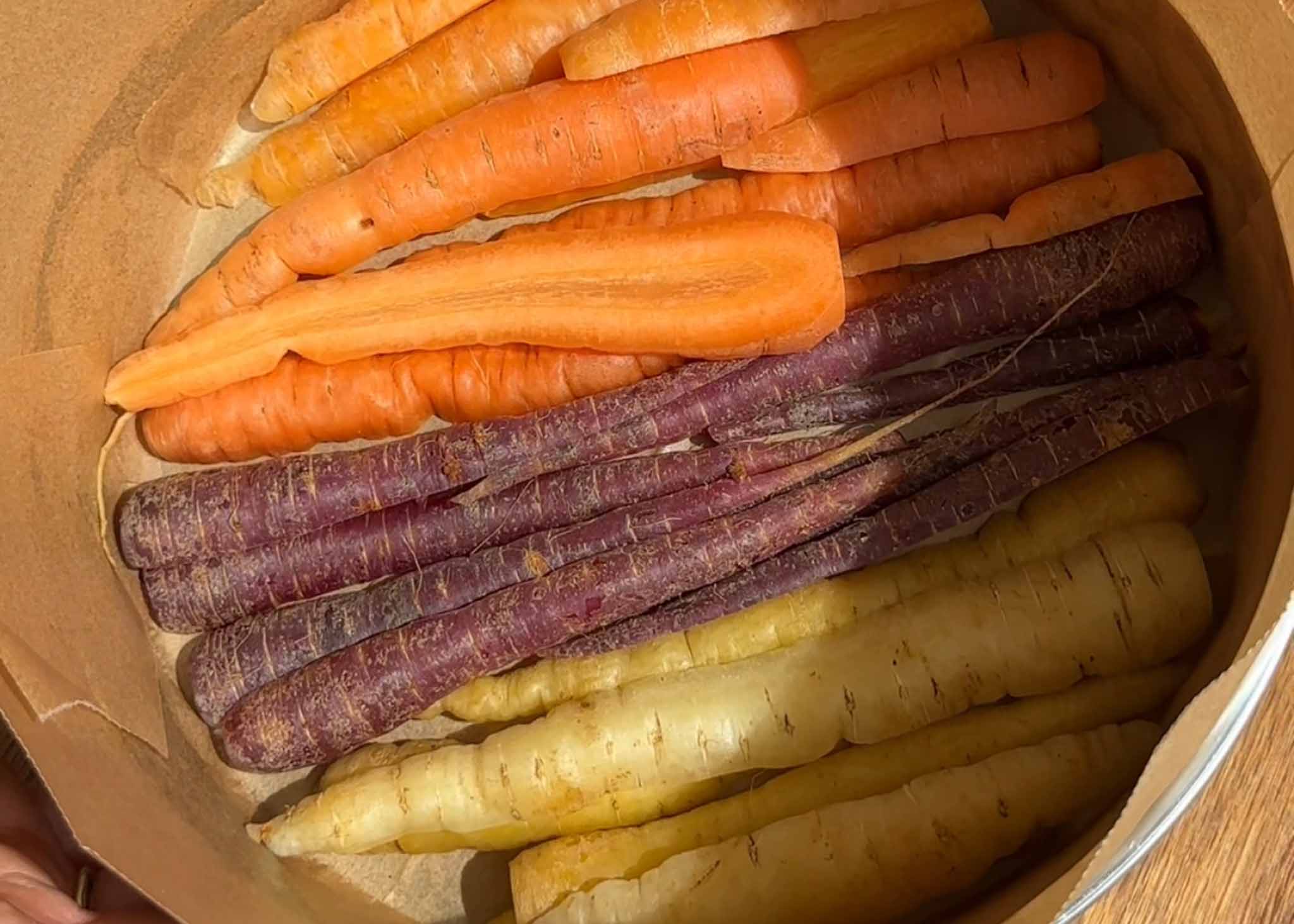 Heirloom carrots arranged tightly in the base of a lined cake tin