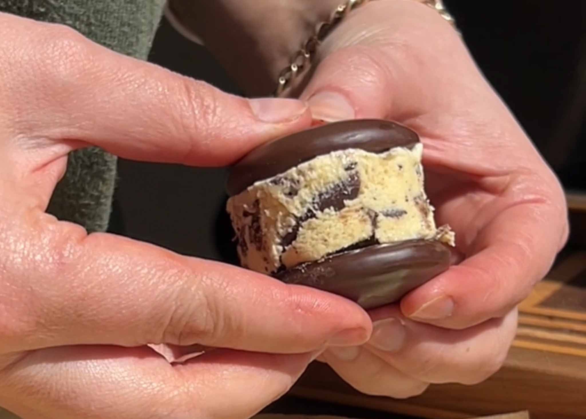 Placing a round of homemade ice cream between two Mint Slice biscuits