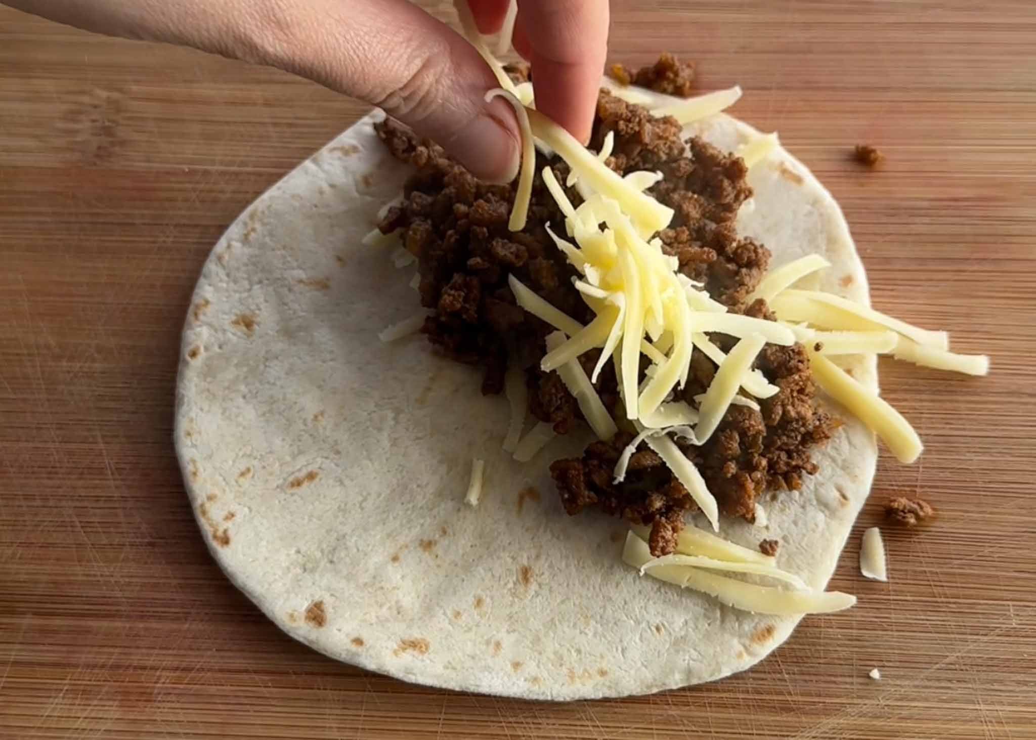 Spiced beef mince and grated Colby cheese added to a flour tortilla
