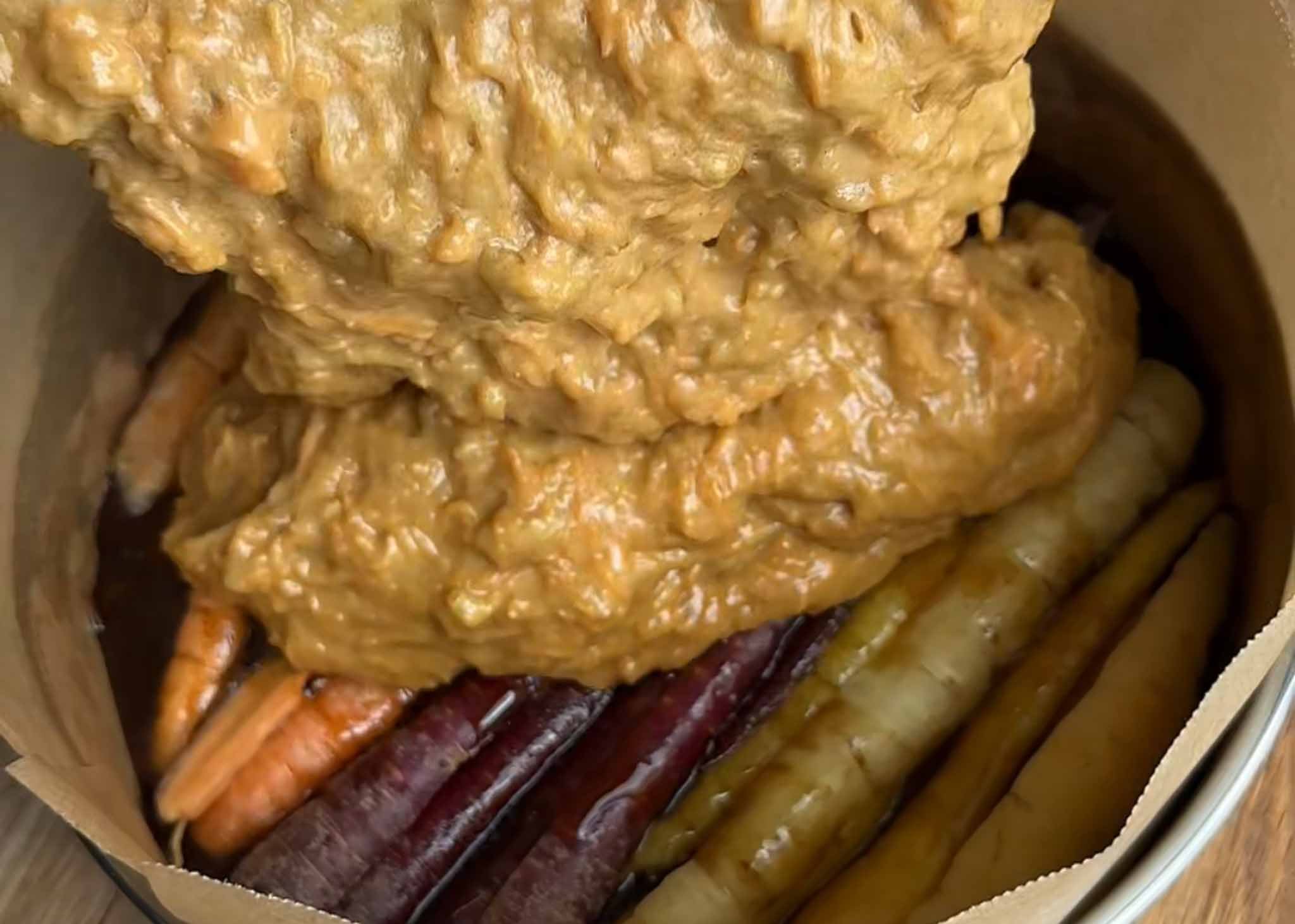 Carrot and walnut cake batter spread over the caramelised carrots