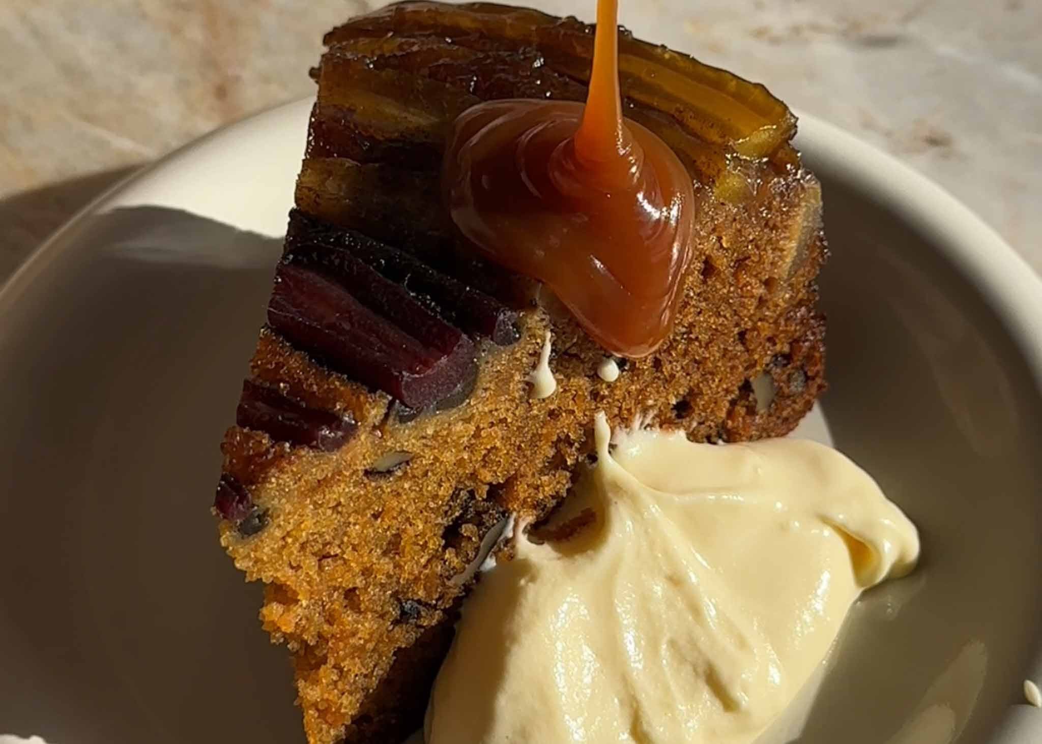 Caramel sauce poured over carrot cake with whipped cream cheese