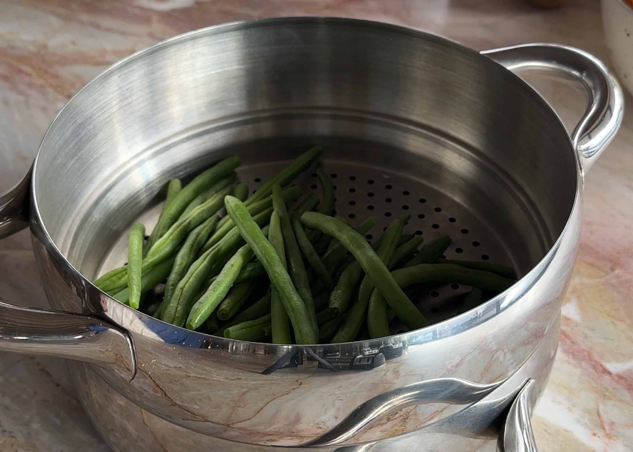 Beans steaming in a saucepan to serve with the beef cheeks
